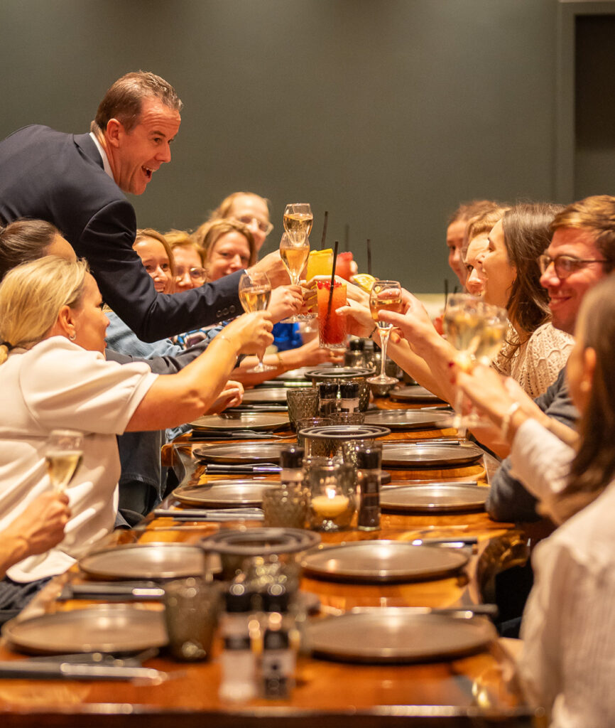 Gasten klinken op een gezellige avond tijdens een feestelijk diner in restaurant Fonduehuis Hasselt